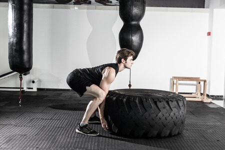 Workout with a big tire in fitness gymの写真素材