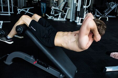 Muscular man exercising doing sit up exercise. Athlete with six pack, white male, no shirt