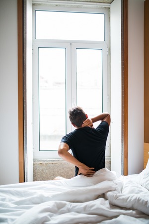 Man feeling back ache in the bed after sleeping