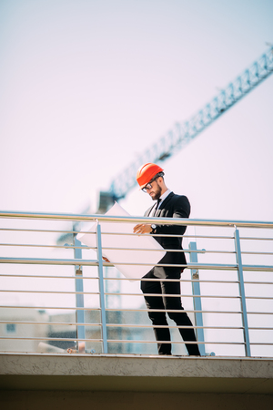 Engineering Consulting people on construction site holding blueprint in his hand. Building inspector. Construction site check drawing and business workflow of new buildingの写真素材
