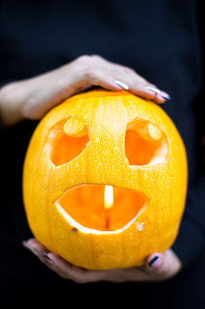 Halloween. Homan hands holding pumpkin on darkの写真素材