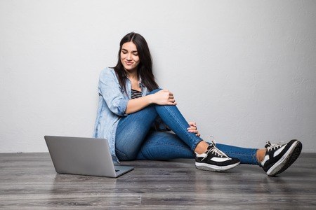 Young creative woman sitting in the floor with laptop.