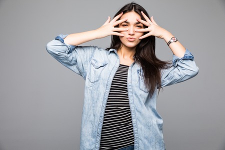 Happy proud young woman showing her hands in front of her face, studio shot grey background.の写真素材
