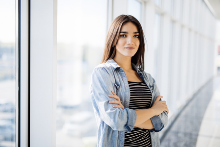 Businesswoman crossed hands portrait in office with panoramic windows.の写真素材