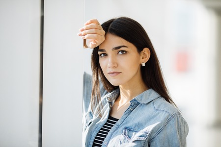 portrait of a beautiful girl on a background of a window