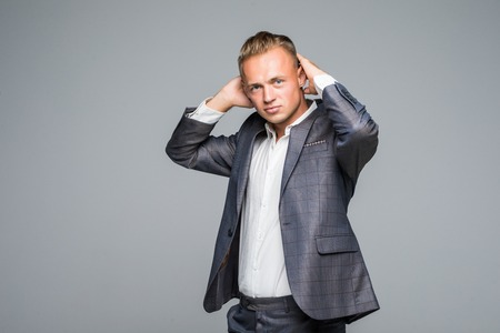 Close up portrait of handsome confident masculine man in jacket touching his hairの写真素材