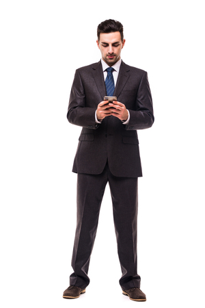 Young bearded business man typing message on smartphone touch screen.の写真素材