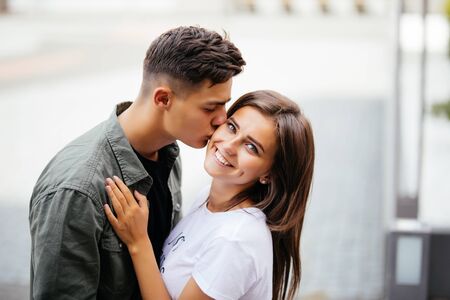 Close-up of a romantic couple kissing, handsome man kissing sensual woman outdoors portrait