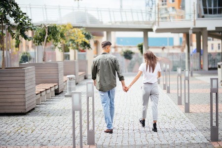 Young dating couple in love walking in city. Business people holding hands on streetの写真素材