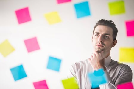 Business man writing on stickers at office