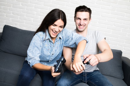 Young couple playing video games. Very candid picture with emotions.の写真素材