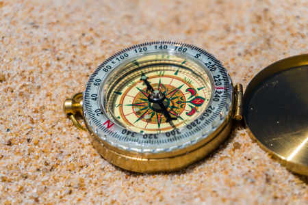 Compass in the sand on the beach.の写真素材