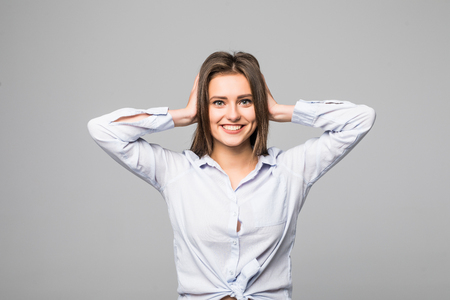 This is too much. Frustrated young woman covering ears by hands and keeping eyes closed while standing against grey backgroundの写真素材