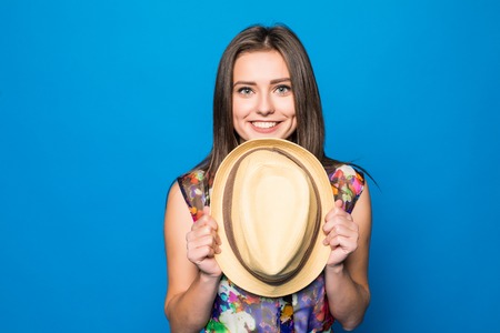 Close-up portrait of a pretty beautiful wearing beach hat close her face isolated on the blue backgroundの写真素材