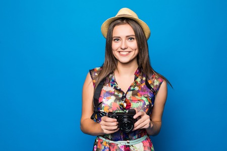 Close up photo of woman in hat on blue background taking a photo with digital cameraの写真素材