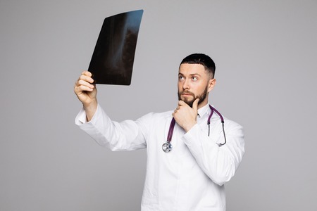 A young medical doctor analyzing a CT scan isolated on white backgroundの写真素材