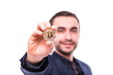Young handsome man pointed golden bitcoin on camera isolatedの写真素材