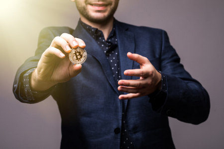 Close up hand with bitcoin of business man isolated on grayの写真素材