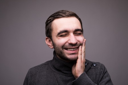 Closeup portrait of young man with tooth ache crown problem about to cry from pain touching outside...