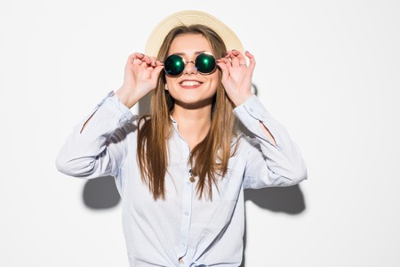 Beautiful young woman in summer clothes and summer hat over a white background