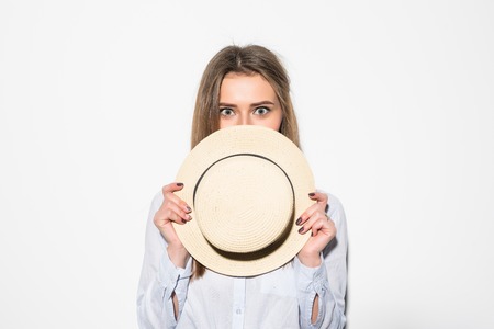 Close up style portrait of smiling woman cover face with hat touching face isolated on white.の写真素材