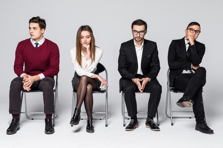Four people wait for job interview sitting on chair isolated on whiteの写真素材