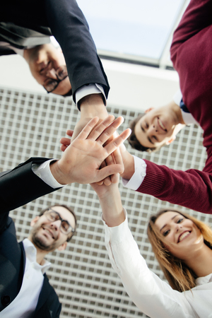 Creative team putting their hands together in circle