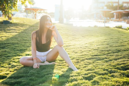 Woman sitting with crossed legs on the green grassの写真素材