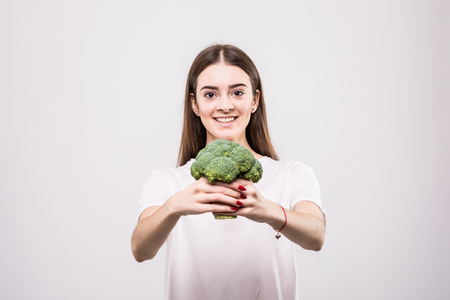 Portrait of a beautiful woman with broccoli, isolated on white.の写真素材
