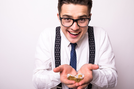 Young man hand holding up golden bitcoin and silver bitcoin in two hand. Close up of bitcoin in open hand isolated on white background.の写真素材