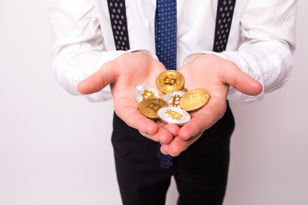 Close up of bitcoin in open hand isolated on whiteの写真素材