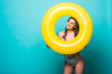 Woman in swimsuit inside inflatable ring and hands isolated over green backgroundの写真素材