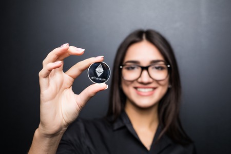 Business woman in glasses with Litecoin in hands isolated on black background.の写真素材