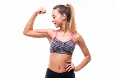 Fitness woman excited on white background. Caucasian female model smiling and showing musclesの写真素材