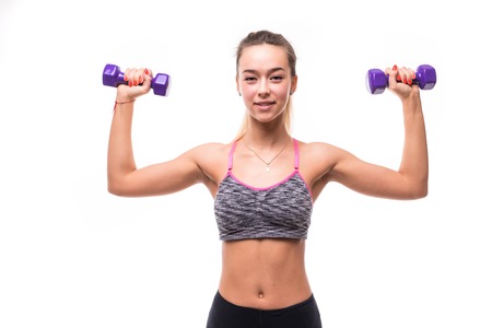 Beautiful young girl working out with dumbbells isolated on whiteの写真素材