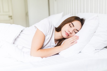 Woman sleeping. Beautiful young smiling woman sleeping in bed