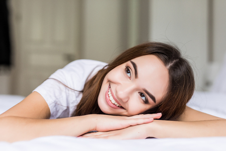 Young woman lying on hands in her bed at home.の写真素材