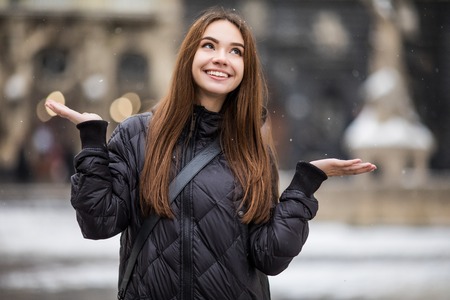 Young beautiful happy smiling girl walking on street.