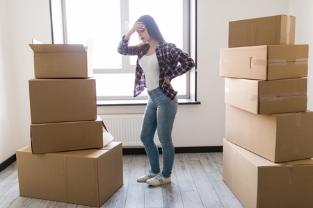 Young woman suffering from pain after moving heavy boxの写真素材