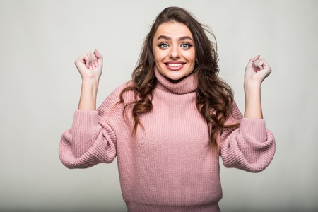 Surprised woman with hands up amazed or shocked by unexpected news holding close palms up and showing happy expression.の写真素材