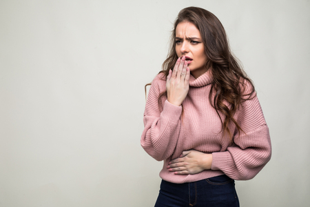 Beautiful girl coughing isolated on a gray backgroundの写真素材