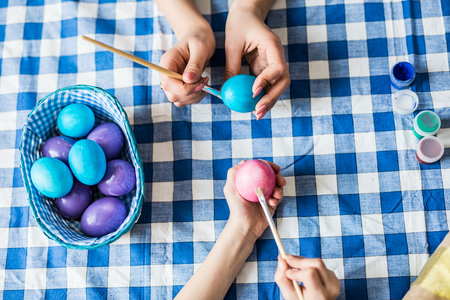 Happy easter. Top view of hands mother their daughter painting Easter eggs.の写真素材