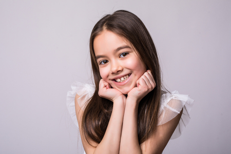 Portrait of adorable smiling little girl isolated on a whiteの写真素材