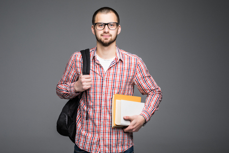 Confident student. Studio portrait of handsome young man holding books.の写真素材
