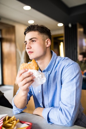 Man is eating in a restaurant and enjoying delicious foodの写真素材