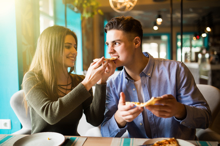 In love Couple eating pizza snack in cafeの写真素材