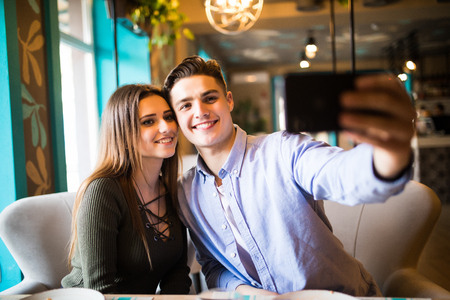 Portrait of an happy couple.They are laughing and eating pizza and having a great time.の写真素材