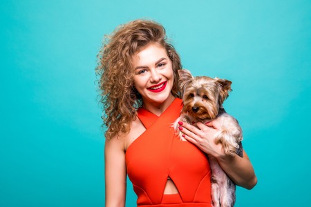 Closeup portrait of smiling young attractive woman looking at camera and embracing Yorkshire terrier. Pet concept.の写真素材
