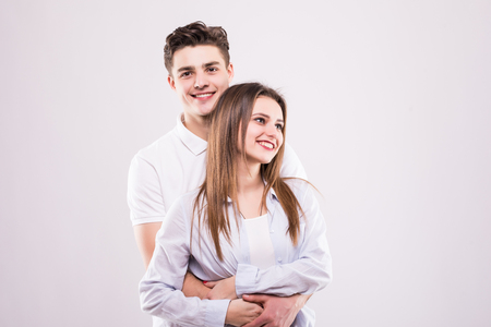 Girl with bronze skin woman and handsome man are standing isolated on grey backgroundの写真素材