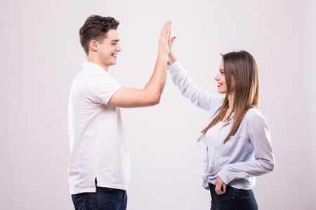 Joyful man and woman greeting each other with a high five isolated on white backgroundの写真素材